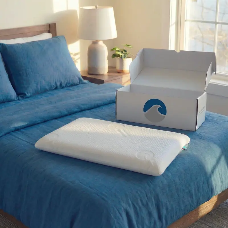 Bluewave Bedding pillow with branded box on bed